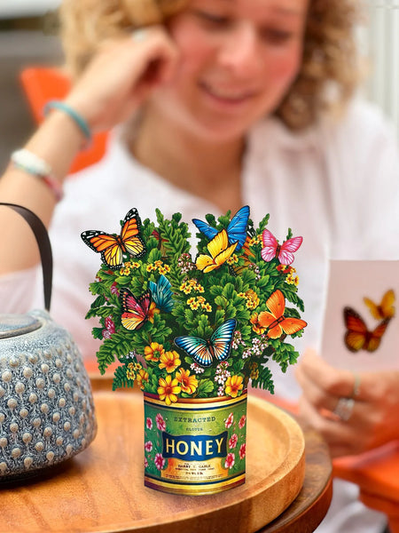 Model reads notecard and Mini butterflies and buttercups greeting card sits on table