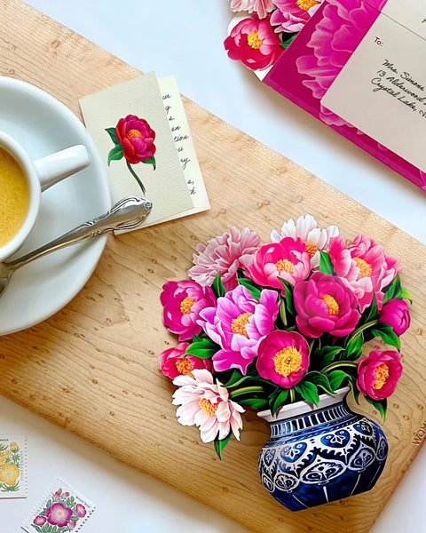 greeting card, notecard and envelope on  table next to a cup of tea