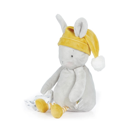 Side view of plush sleepy bloom bunny, white with yellow feet, yellow and white striped legs and yellow had