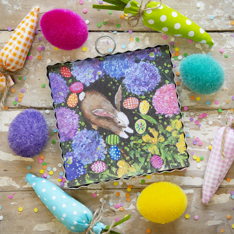 Cute brown bunny nestles among colorful flowers and easter eggs
