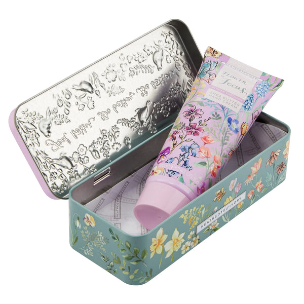 Blue and pink floral tin opened to reveal a tube of Flower of Focus shea butter hand cream