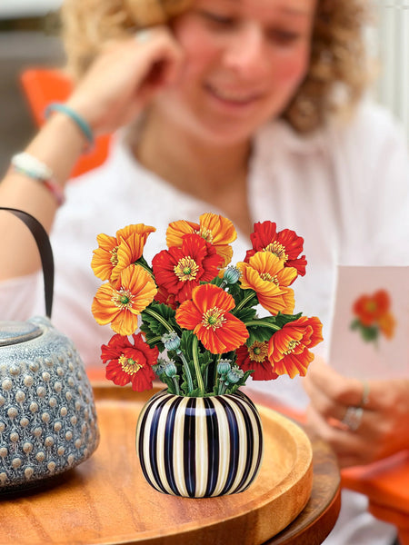 Model reads note card in background with greeting card on table in foreground