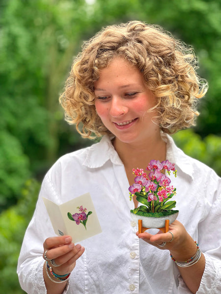 Model holds greeting card in her hand while reading notecard