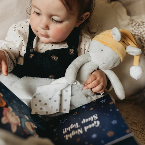 Toddler hold open book, "Good Night Sleep Tight" Story Book and  holding plush bunny