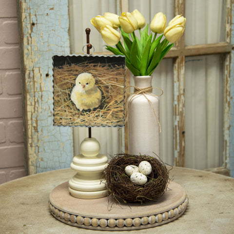 Baby chick in a nest picture placed on easel in Easter display