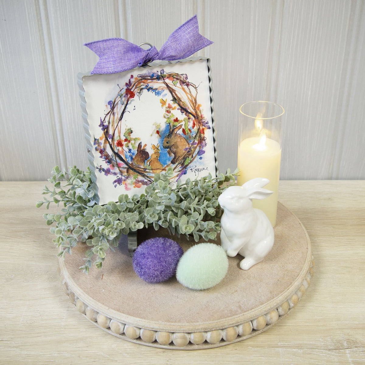 Watercolor Bunny Wreath Print on table display with candle, ceramic bunny and easter eggs