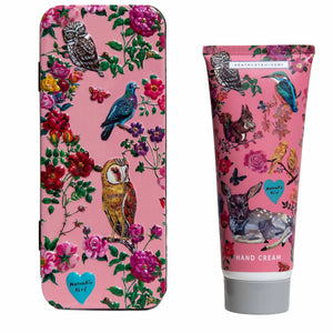 Colorful tin decorated with owls, birds and flowers alongside hand cream 