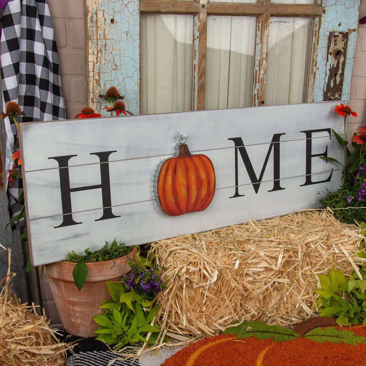 White mini gallery "Home" display board with pumpkin hanging on it
